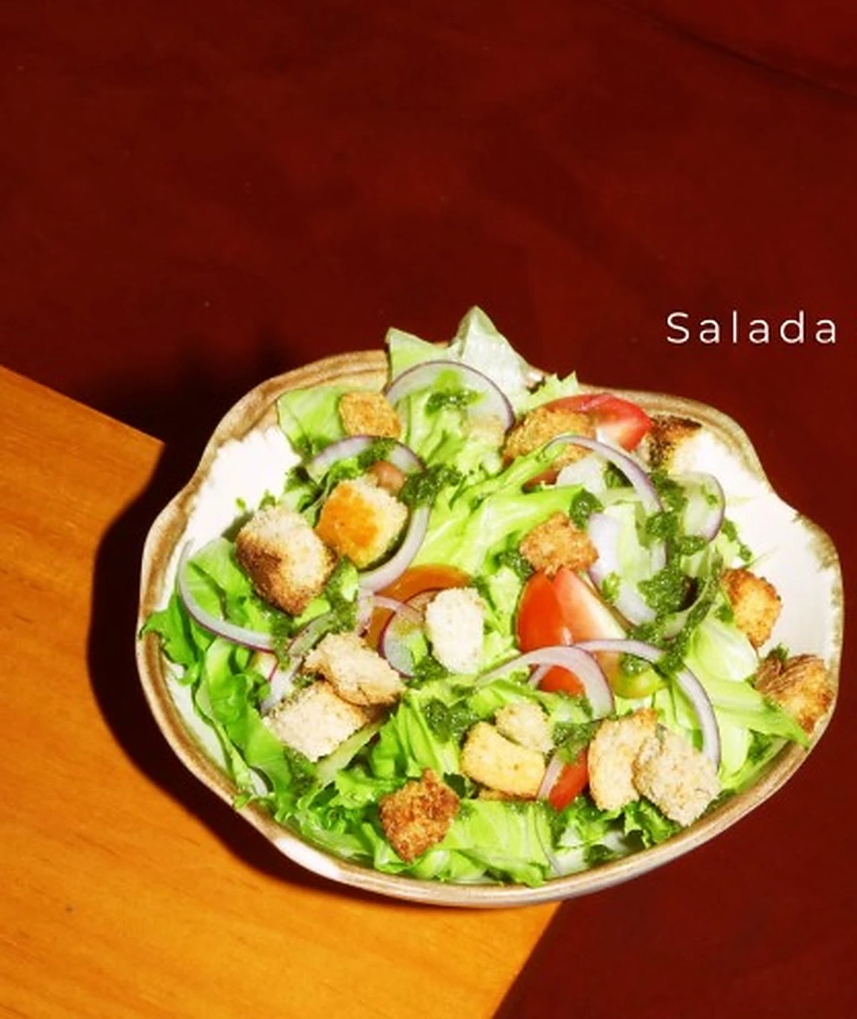 Salada da casa com folhas verdes, tomate, cebola roxa e croutons