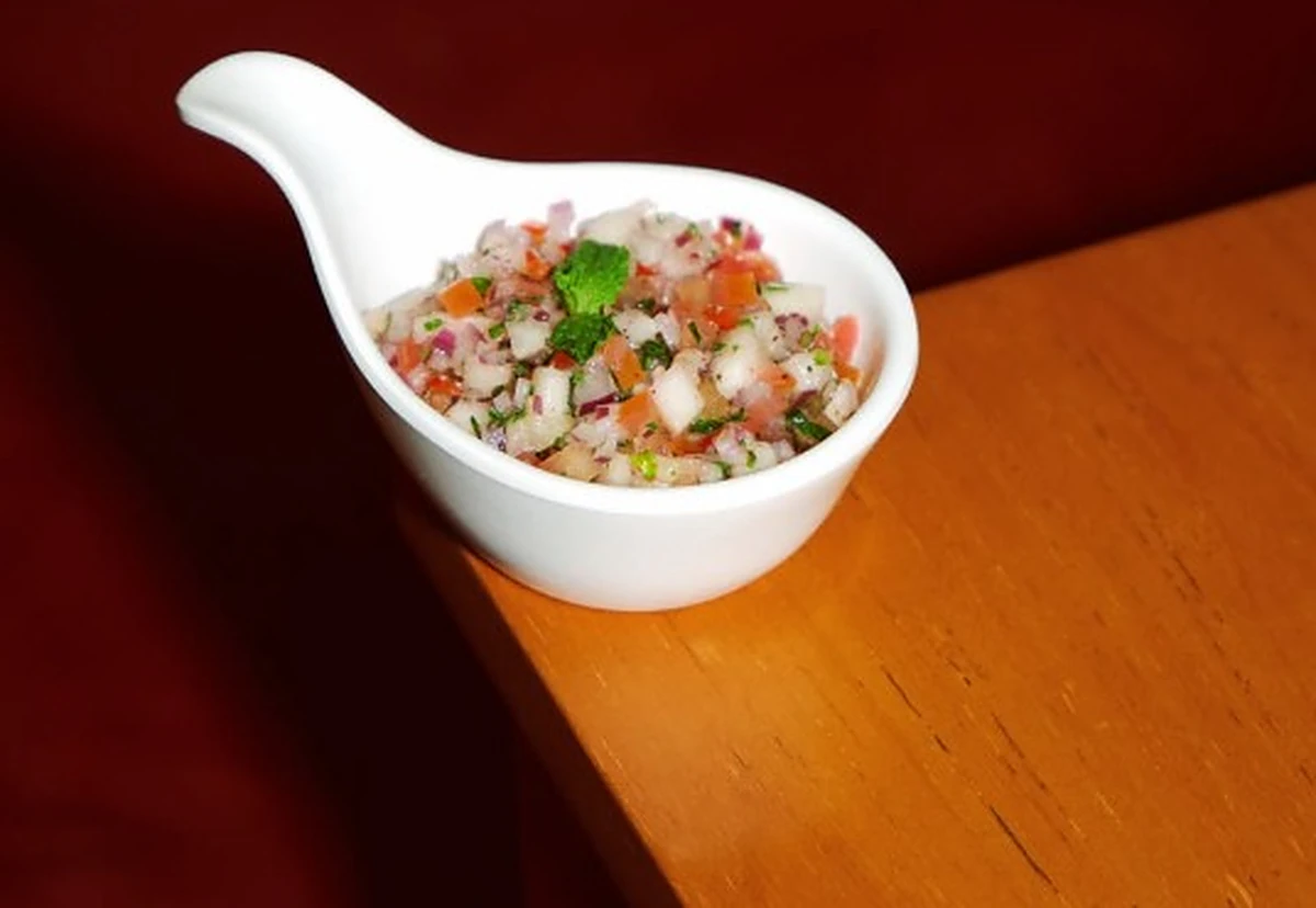 Vinagrete de abacaxi com tomate e hortelã em colher de porcelana branca