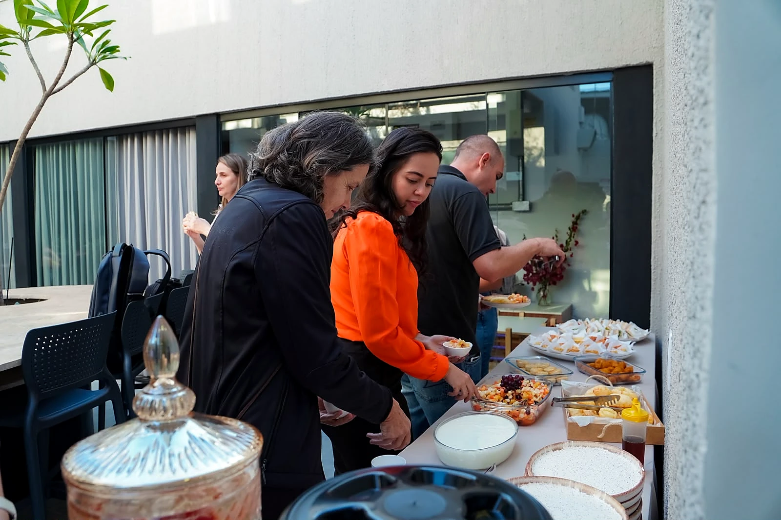 Convidados reunidos diante do buffet em evento do Lumne